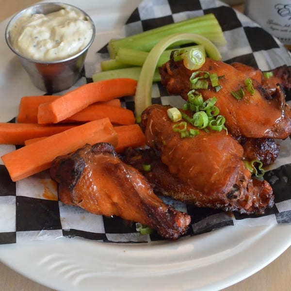 Tchotchke's American-style chicken wings with carrots, celery, and a side of ranch dressing.